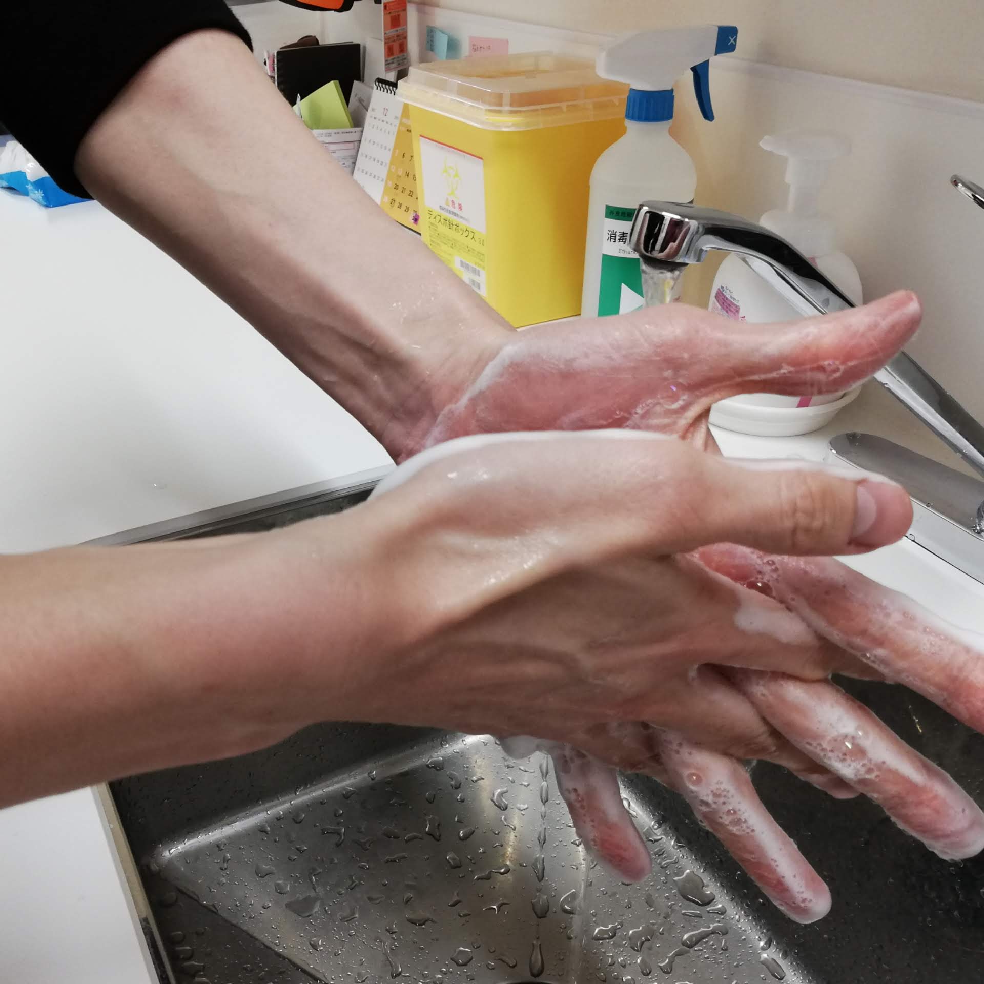 両方の手のひらを合わせこすり、指を組んで指の間を洗う